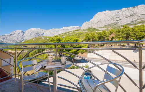 a table on a balcony with a view of mountains at Lovely Apartment In Krvavica With Wifi in Krvavica