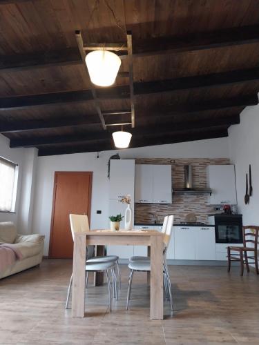 eine Küche und ein Esszimmer mit einem Holztisch und Stühlen in der Unterkunft Casal Baratz in Santa Maria la Palma