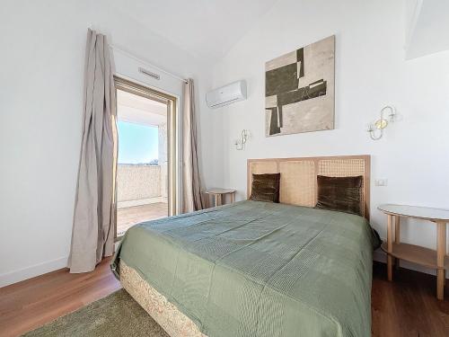 une chambre avec un lit et une grande fenêtre dans l'établissement Intuition Duplex 3 lits terrasse 5mn Palais et Croisette, à Cannes