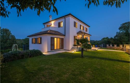 a large white house with lights on a yard at 4 Bedroom Gorgeous Home In Krk in Krk