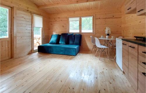 a living room with a blue couch in a cabin at Stunning Home In Pobierowo With Kitchen in Pobierowo