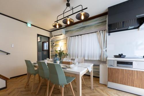 a kitchen and dining room with a table and chairs at OB 関西空港 大阪梅田 心斎橋直通 京セラドーム1分 usj10分 静かな住宅街 専用駐車場付き in Osaka