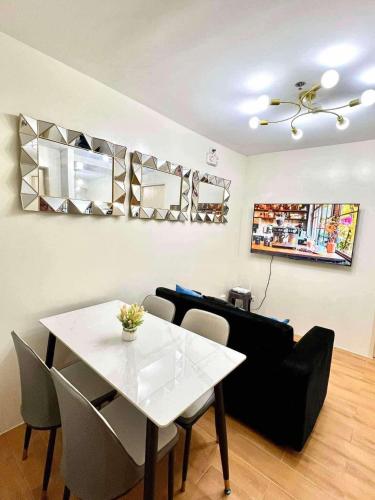 a living room with a white table and a black couch at Seawind Condo Near Airport and Sm Lanang in Davao City