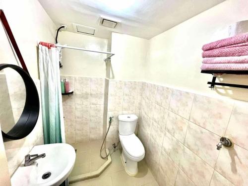 a bathroom with a toilet and a sink and a shower at Seawind Condo Near Airport and Sm Lanang in Davao City