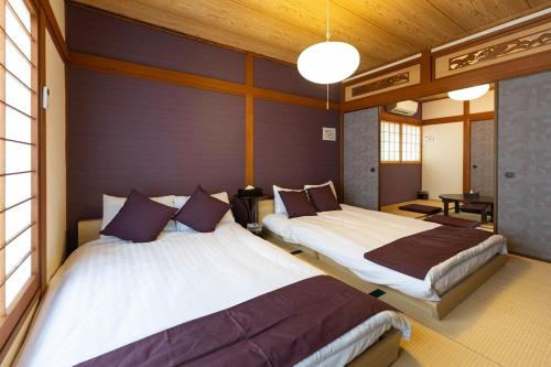 a room with two beds in a room at OB 関西空港 大阪梅田 心斎橋直通 京セラドーム1分 usj10分 静かな住宅街 専用駐車場付き in Osaka
