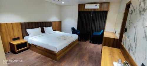 une chambre avec un lit, un bureau et une chaise dans l'établissement Hotel Centrum, à Siliguri