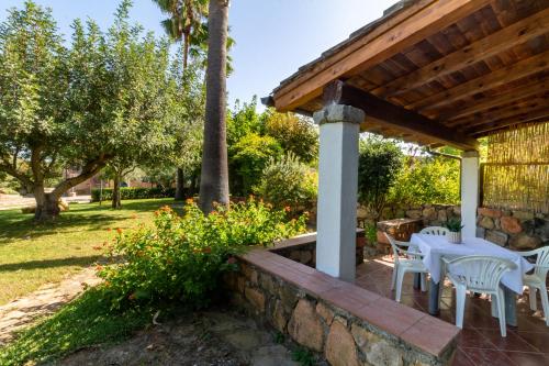 a patio with white tables and chairs on a stone wall at Residenza Melissa, appartamenti in Jerzu