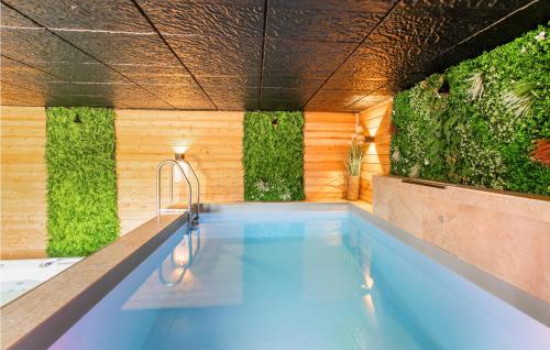- une piscine avec des plantes sur les murs dans l'établissement Cozy Home In Le Mesnil-Jourdain, à Le Mesnil-Jourdain