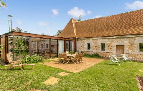une maison avec un patio avec une table et des chaises dans l'établissement Cozy Home In Le Mesnil-Jourdain, à Le Mesnil-Jourdain