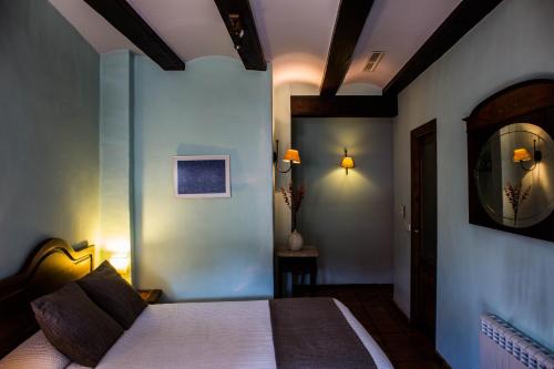 a hotel room with a bed and a mirror at La Font D'Alcala in Alcalá de la Jovada