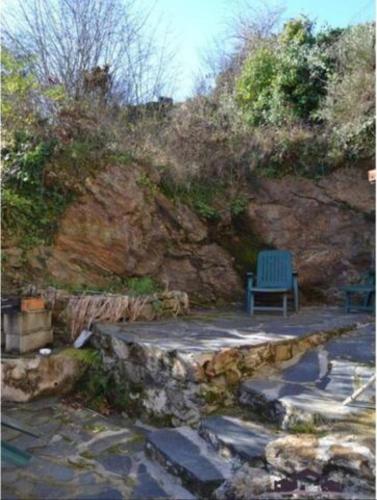 un banc bleu assis sur une passerelle en pierre dans l'établissement Gîte La Fount, à Montoulieu