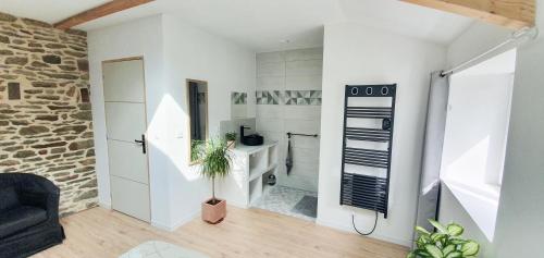 - un salon avec des murs blancs et un mur en pierre dans l'établissement Belle maison familiale dans la campagne Bretonne, à La Croix-Helléan