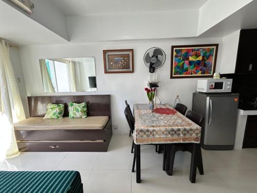 a room with a table and a bed and a table and chairs at Condominium EC Accommodation in Baguio