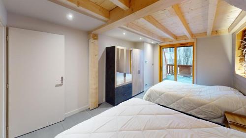 a bedroom with two beds and a tv in it at Les Neiges in Saint-Sorlin-dʼArves