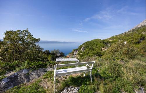 a white bench sitting on a hill overlooking a lake at Apartment Vojskovo Ii in Lokva Rogoznica