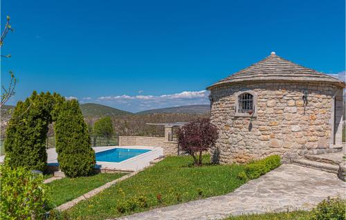 a stone building with a swimming pool in a yard at Two-Bedroom Holiday Home In Kijevo in Kijevo