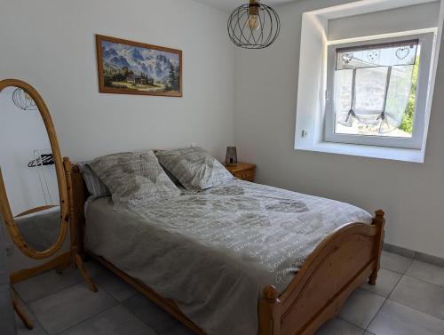 - un lit dans une chambre avec un miroir et une fenêtre dans l'établissement Gite La grange de Louis SPA et SAUNA, à Araules