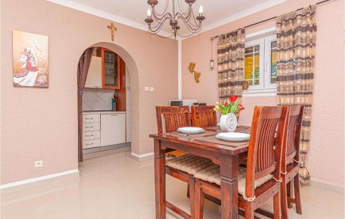 a dining room with a wooden table and chairs at Two-Bedroom Holiday Home In Kijevo in Kijevo