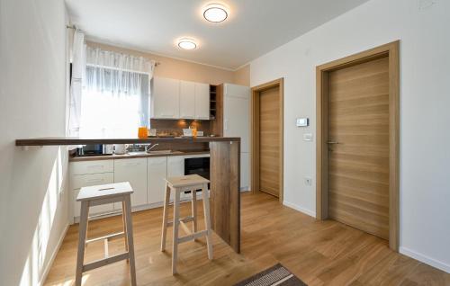 a kitchen with white cabinets and a counter and stools at Pet Friendly Home In Margecan in Gačice