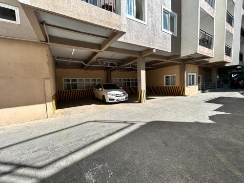 a car parked in a parking lot next to a building at Condominium EC Accommodation in Baguio
