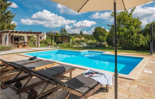 una piscina con sombrilla, mesa y sillas en Holiday Home Heki Cr, en Pazin