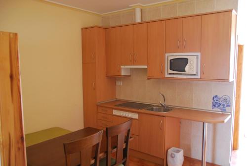 a small kitchen with a table and a microwave at Alojamiento Rural Los Delfines in Valdepeñas