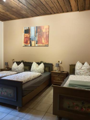 a bedroom with two beds and a painting on the wall at Steinhaus / Kamenny Dum in Zdíkov