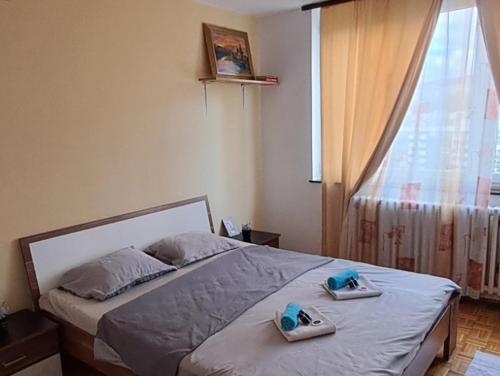 a bedroom with a bed with two slippers on it at Sarajevo Apartment by Didi 4U2STAY free parking in Sarajevo