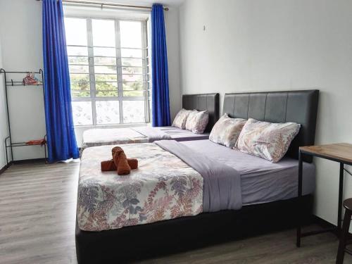 a teddy bear sitting on a bed in a bedroom at IRDINA HomestayMuslim's 2 at Emerald Avenue Brinchang Centrum in Brinchang