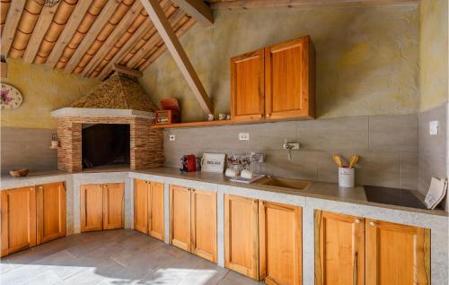 a kitchen with wooden cabinets and a brick oven at Cozy Apartment In Cerovlje With Wifi in Cerovlje