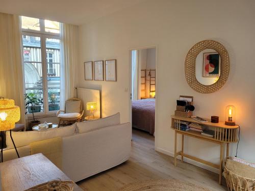 - un salon avec un lit et un miroir dans l'établissement My Beauvoisine, à Rouen