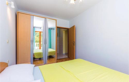 a bedroom with a yellow bed and a mirror at Nice Apartment In Povile With Wifi in Povile