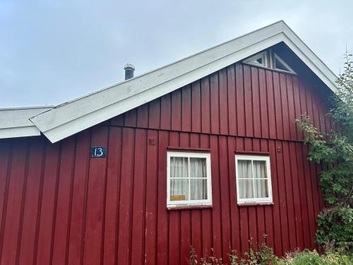 a red barn with two windows and a roof at Convenient ski in-out on Norefjell in the alpine village in Surteberg