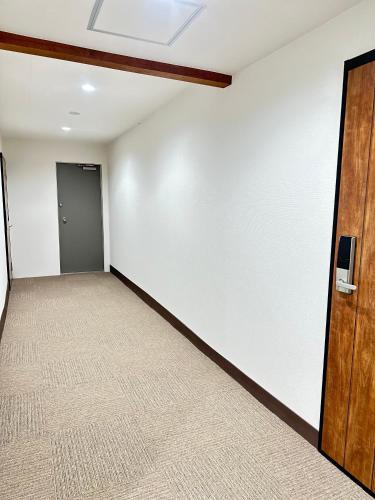 an empty room with a white wall and a door at MA House in Osaka
