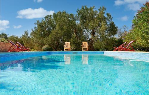 two chairs sitting next to a swimming pool at 4 Bedroom Awesome Home In Lun in Lun