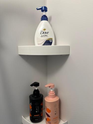 a shelf with a bottle of soap and a soap dispenser at MA House in Osaka