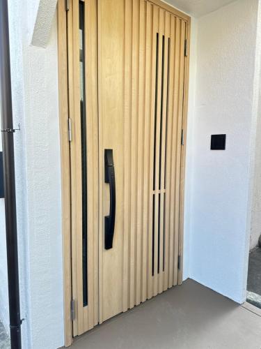 a wooden door with a black handle in a room at MA House in Osaka