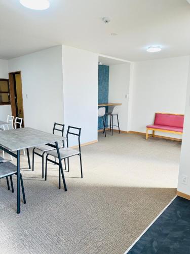 a room with a table and chairs and a couch at MA House in Osaka