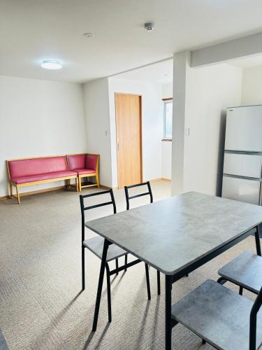 a room with a table and chairs and a couch at MA House in Osaka