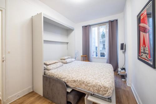 une petite chambre avec un lit et une fenêtre dans l'établissement Studio de charme au cœur du Marais, à Paris