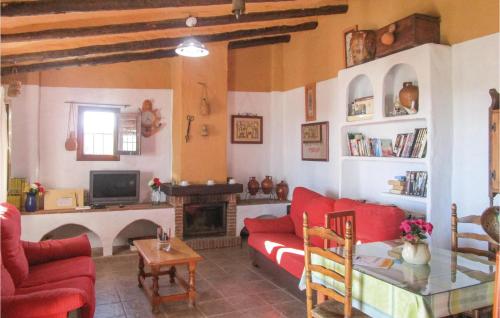 a living room with a red couch and a fireplace at 2 Bedroom Amazing Home In Frigiliana in Frigiliana