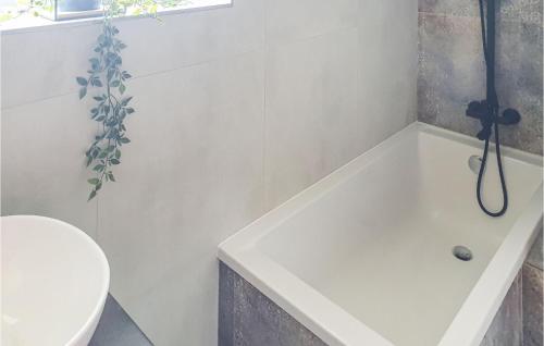 a bathroom with a bath tub and a toilet at 3 Bedroom Gorgeous Home In Podamirowo in Podamirowo