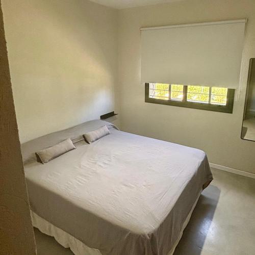 a bedroom with a white bed with two pillows on it at Rincon de Lobos in La Estafeta
