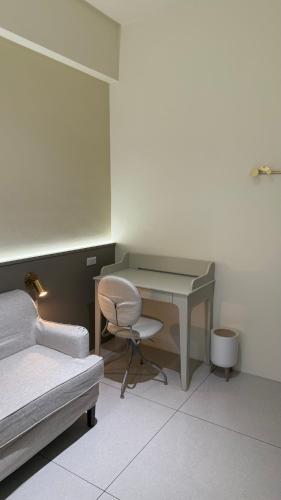 a bedroom with a desk and a bed and a chair at 鹿港 尋鹿好旅 民宿 in Lugang