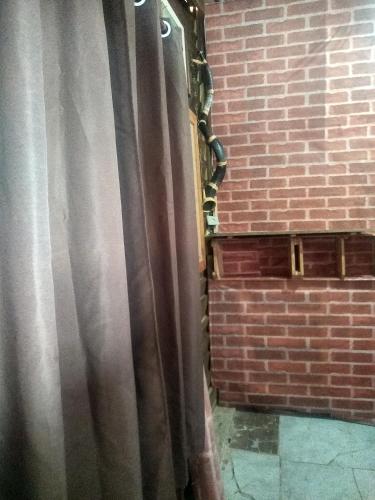 a curtain in a room with a brick wall at Mantiqueira lar doce lar in Gonçalves