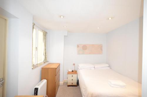 a white bedroom with a bed and a window at Amber Residence Hotel-Suites in London