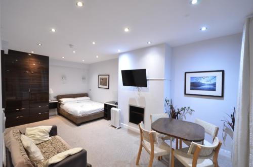 a living room with a bed and a table at Amber Residence Hotel-Suites in London