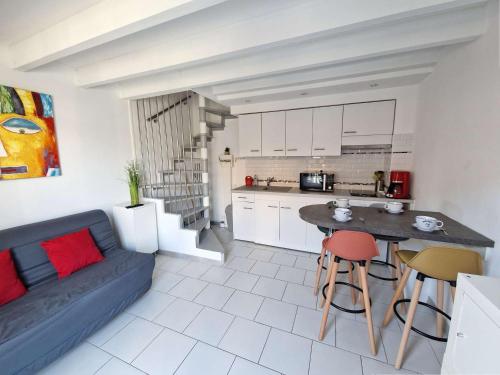 un salon avec un canapé bleu et une cuisine dans l'établissement Maison rénovée avec piscine, parking privé et proche plage à Marseillan - FR-1-387-185, à Marseillan