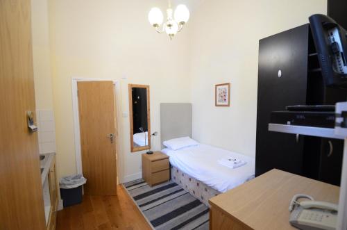 a small room with a small bed and a door at Amber Residence Hotel-Suites in London