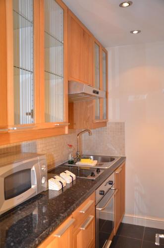 a kitchen with a sink and a microwave at Amber Residence Hotel-Suites in London